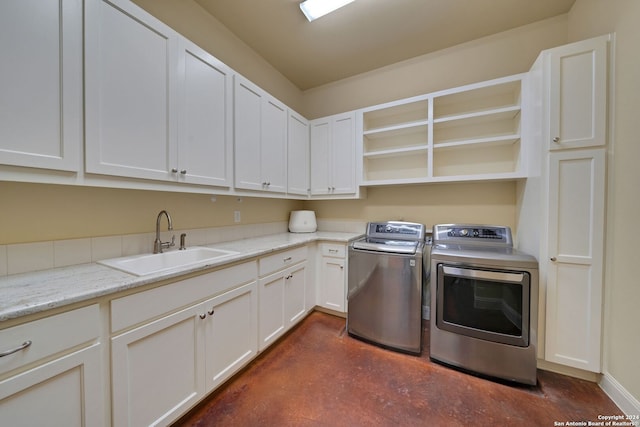 clothes washing area featuring sink, independent washer and dryer, and cabinets