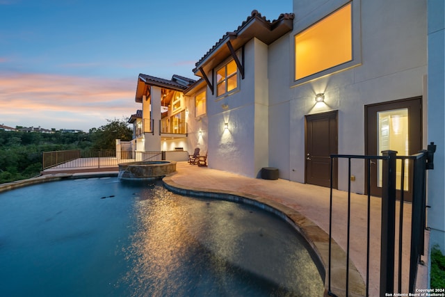 pool at dusk with a patio