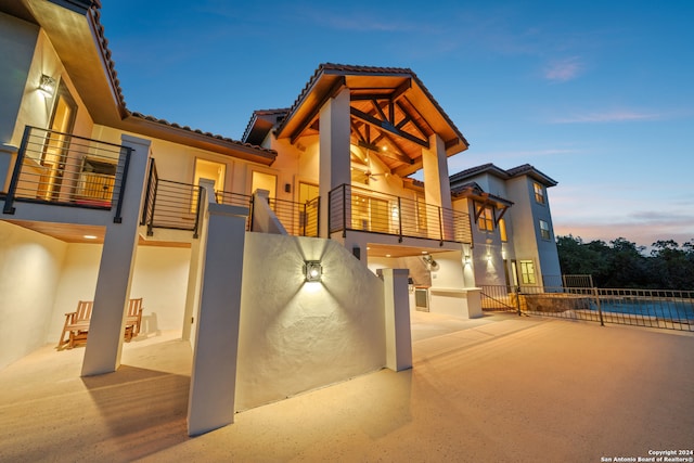 exterior space featuring a fenced in pool and a balcony