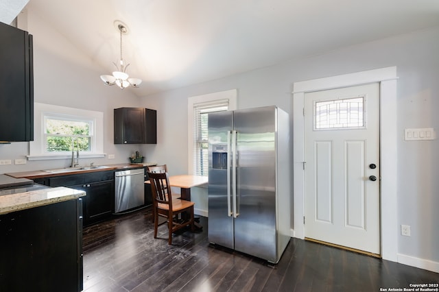 kitchen featuring stainless steel appliances, hanging light fixtures, sink, and dark hardwood / wood-style flooring