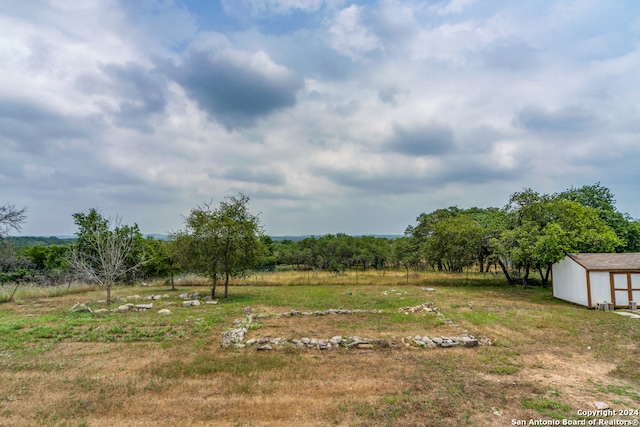 view of yard with a storage unit and a rural view