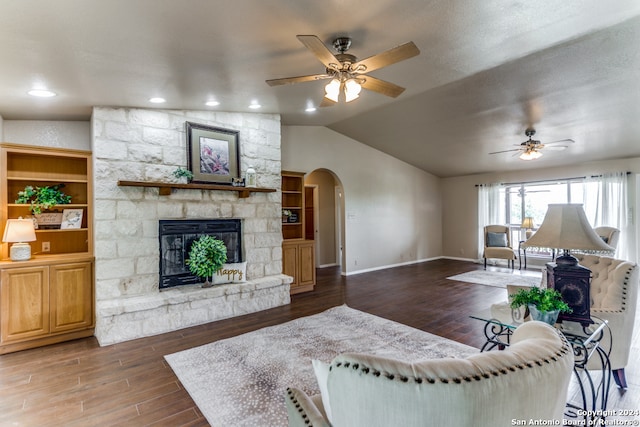 living room featuring a stone fireplace, wood-type flooring, ceiling fan, and vaulted ceiling