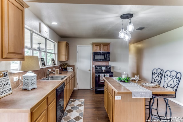 kitchen featuring dark hardwood / wood-style floors, a kitchen island, stove, a breakfast bar area, and sink