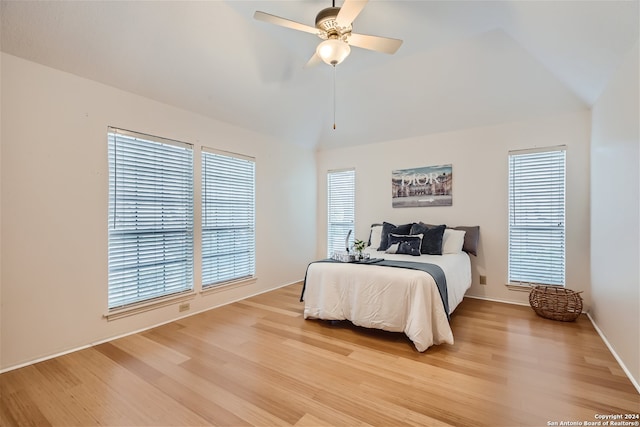 bedroom featuring lofted ceiling, ceiling fan, light hardwood / wood-style floors, and multiple windows