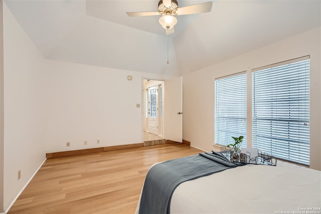 bedroom featuring ceiling fan, light hardwood / wood-style flooring, and lofted ceiling