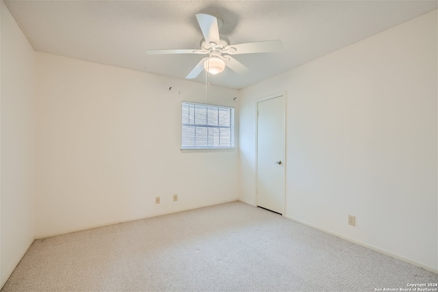 unfurnished room with ceiling fan and light colored carpet