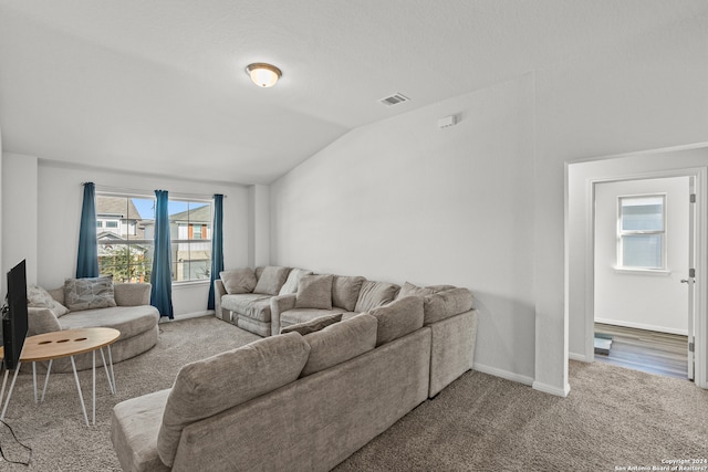 carpeted living room featuring lofted ceiling