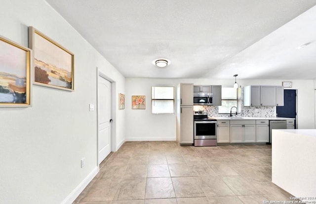 kitchen featuring tasteful backsplash, stainless steel appliances, light tile flooring, gray cabinetry, and sink