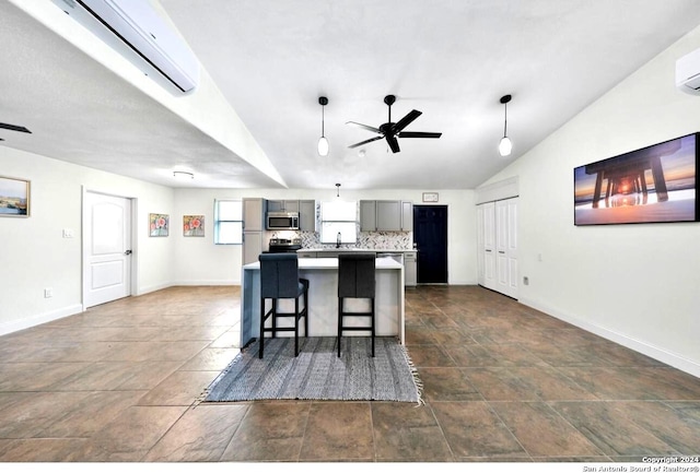 kitchen featuring decorative light fixtures, vaulted ceiling, dark tile floors, backsplash, and a center island