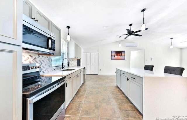 kitchen featuring stainless steel appliances, sink, tasteful backsplash, and decorative light fixtures