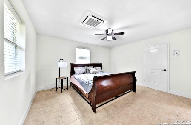 tiled bedroom featuring ceiling fan and multiple windows