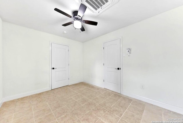 tiled empty room featuring ceiling fan