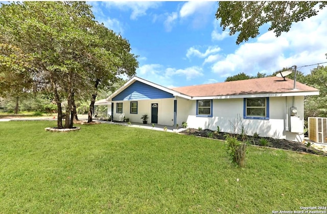 rear view of property featuring central AC unit and a lawn