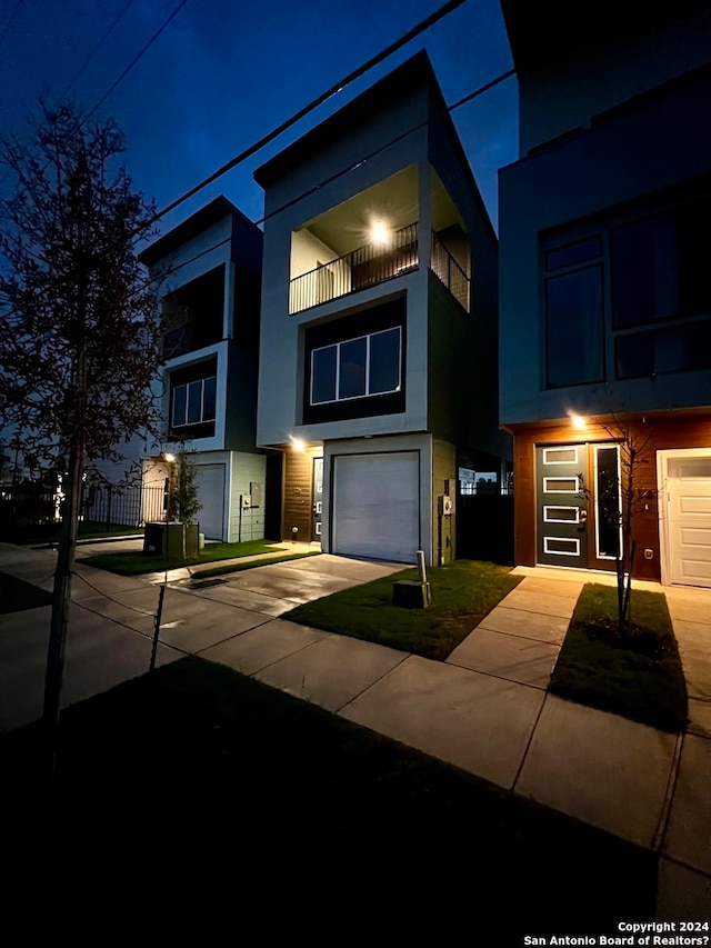 view of front of property featuring a garage and a balcony