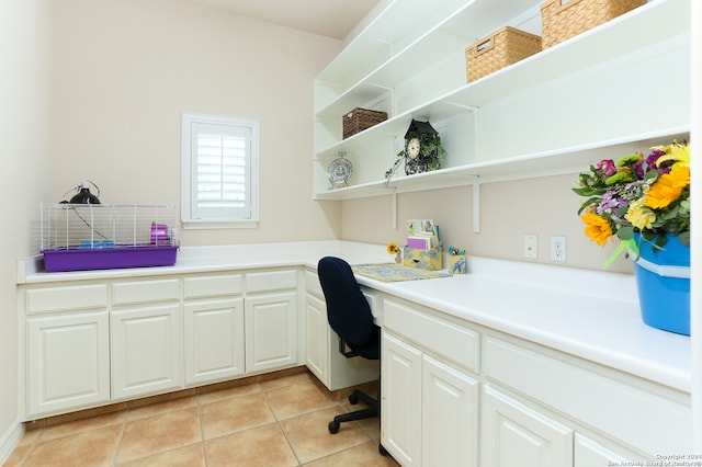 office space with built in desk and light tile patterned flooring