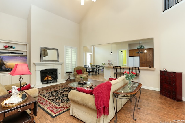 living room featuring light wood-type flooring and high vaulted ceiling