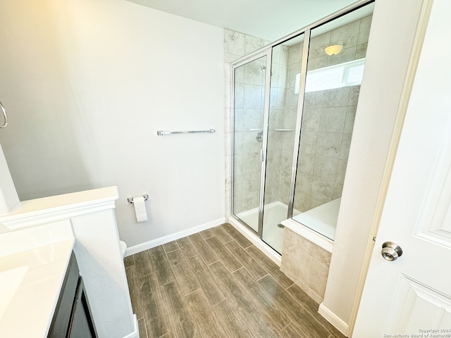 bathroom featuring a shower with door, wood-type flooring, and vanity