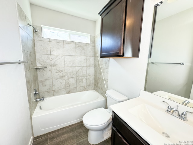 full bathroom with tiled shower / bath, vanity, toilet, and hardwood / wood-style floors