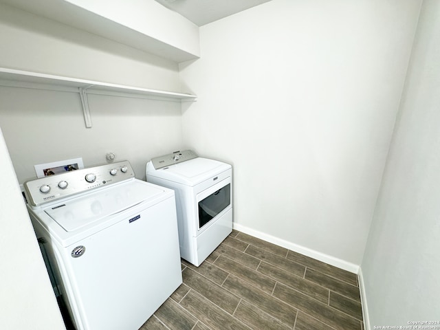 laundry area featuring dark wood-type flooring, washer and clothes dryer, and washer hookup