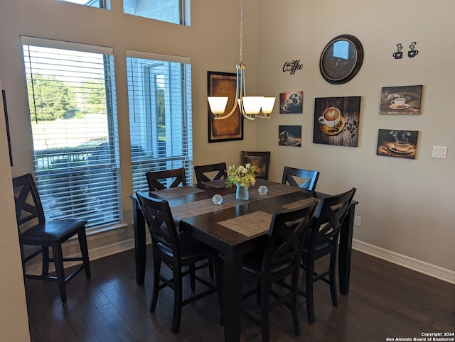 dining space featuring dark wood-type flooring and a notable chandelier