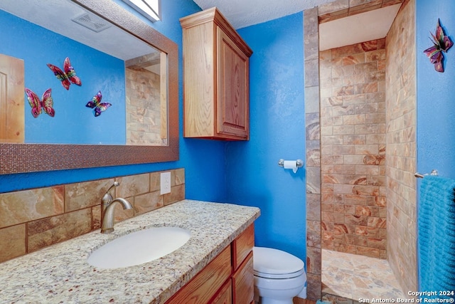 bathroom with a textured ceiling, toilet, and vanity