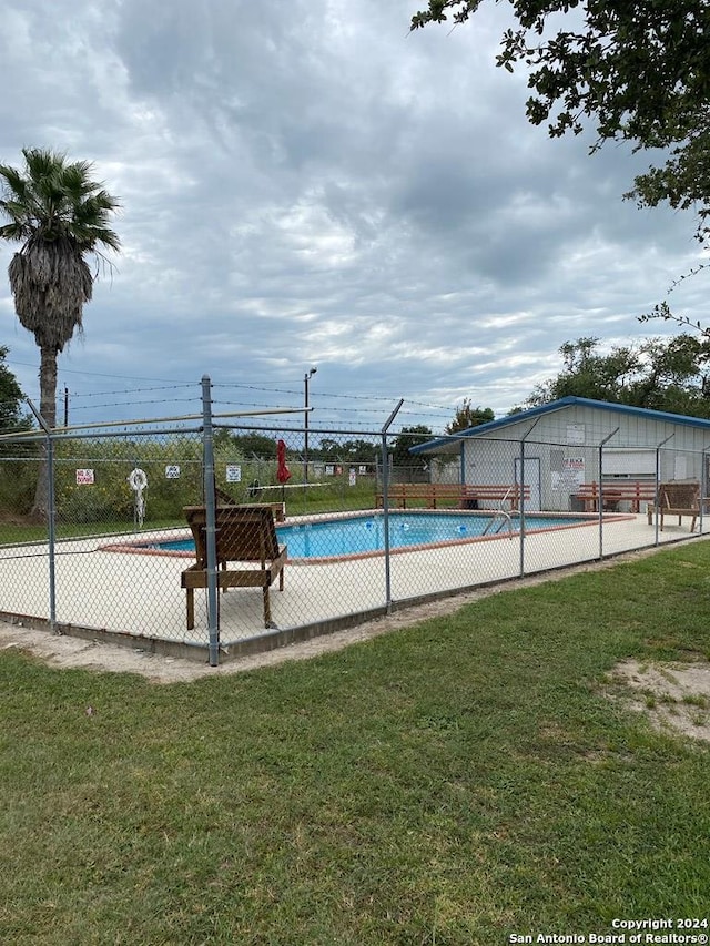 view of swimming pool featuring a yard