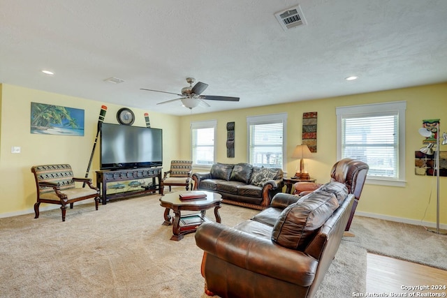 living room with ceiling fan and a textured ceiling