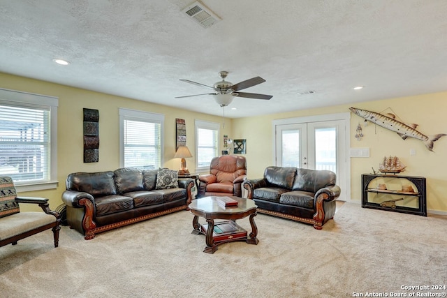 living room featuring a textured ceiling, ceiling fan, french doors, and carpet floors