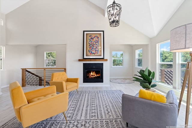 living room featuring a chandelier, high vaulted ceiling, and wood-type flooring