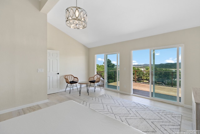 interior space with high vaulted ceiling, a chandelier, and light hardwood / wood-style floors