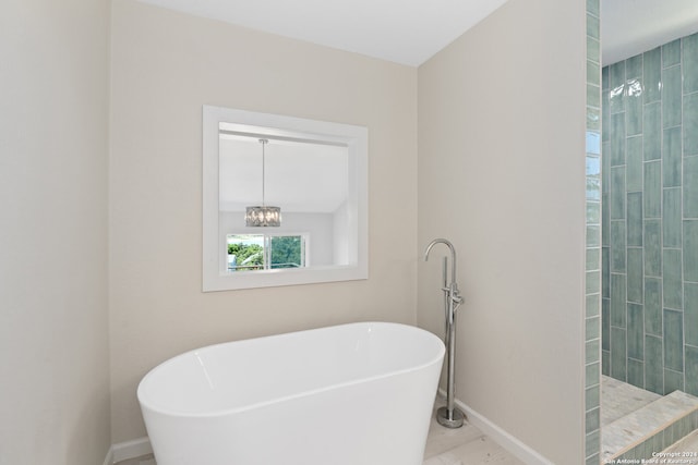 bathroom featuring tile floors, a chandelier, and a washtub