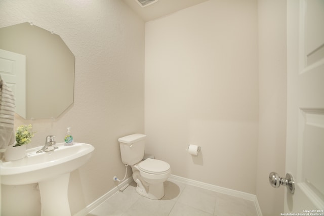 bathroom featuring toilet and tile floors