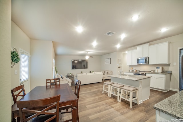 dining area featuring sink, light wood-type flooring, and ceiling fan