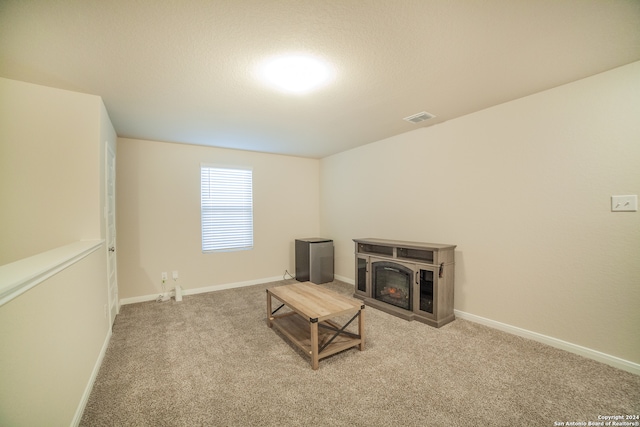 living area featuring carpet flooring and a fireplace