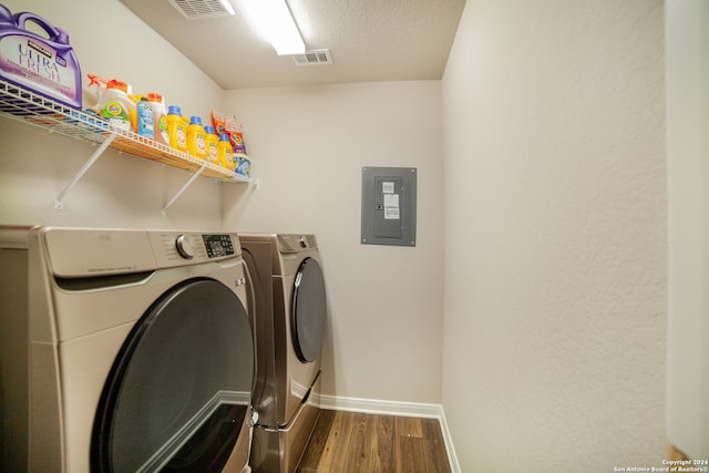 laundry area featuring washing machine and dryer, a textured ceiling, and wood-type flooring