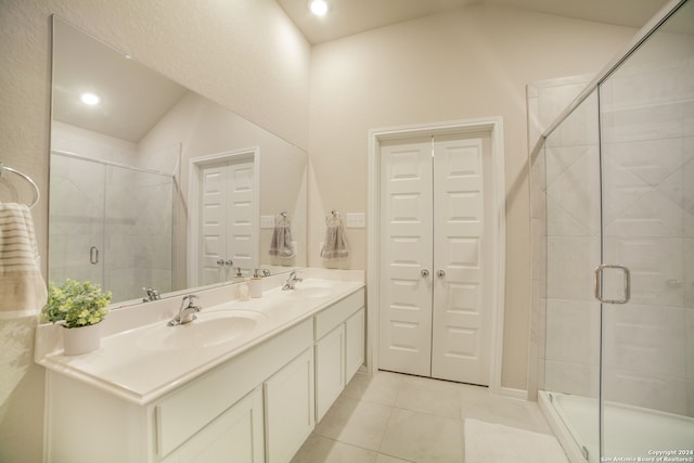 bathroom featuring large vanity, tile flooring, double sink, and vaulted ceiling