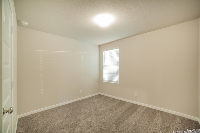 carpeted spare room featuring a textured ceiling