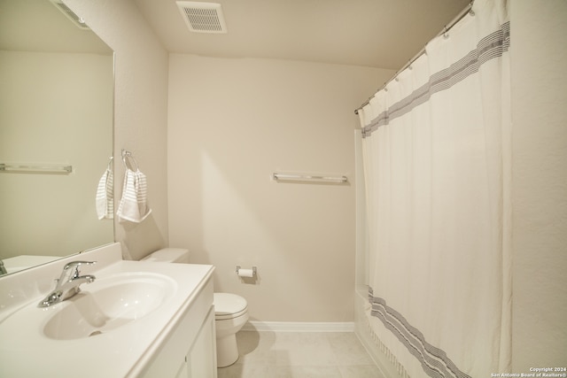 bathroom with tile floors, oversized vanity, and toilet