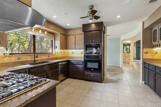 kitchen featuring island exhaust hood, tasteful backsplash, black appliances, dark brown cabinetry, and sink