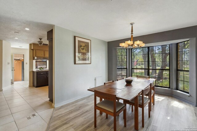 dining area with light tile flooring and an inviting chandelier