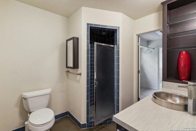 bathroom featuring a shower with door, toilet, and vanity