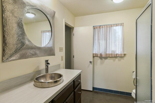 bathroom featuring a healthy amount of sunlight, vanity, and toilet