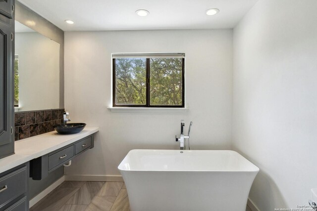 bathroom with a bath, tile floors, and large vanity