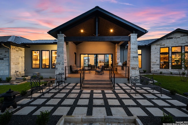 back house at dusk with a patio area