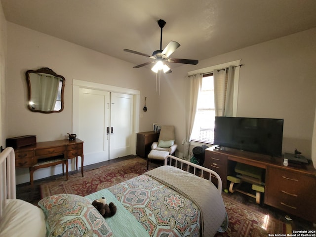 bedroom with dark hardwood / wood-style flooring and ceiling fan