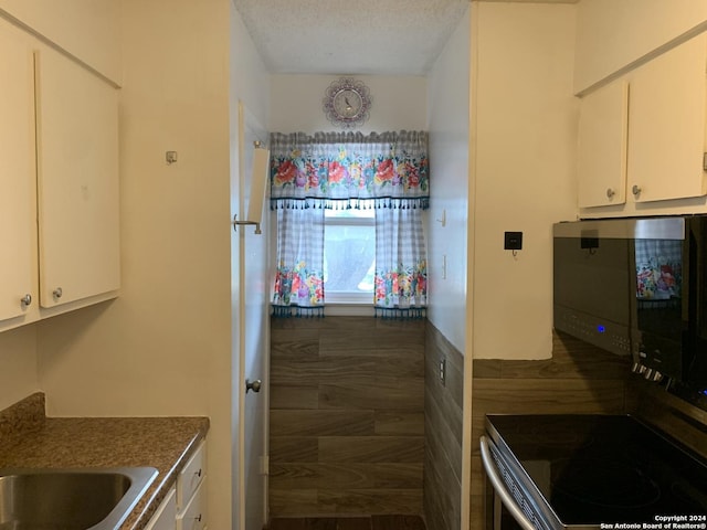 923 Vance Jackson Rd Unit 108A, San Antonio, TX 78201 - kitchen featuring white cabinetry, a textured ceiling, and dark countertops