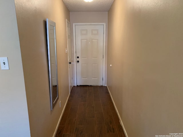 hallway featuring a textured ceiling and wood-type flooring