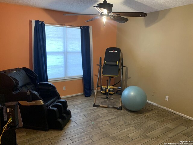 923 Vance Jackson Rd Unit 108A, San Antonio, TX 78201 - exercise room with a ceiling fan, a textured ceiling, wood tiled floors, and baseboards