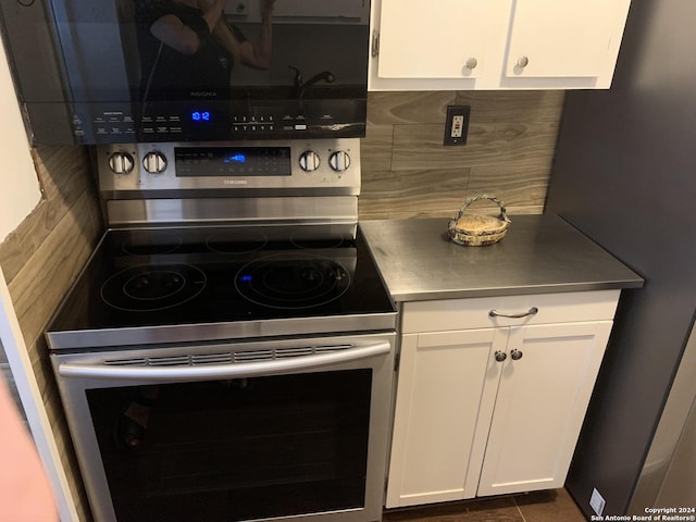 923 Vance Jackson Rd Unit 108A, San Antonio, TX 78201 - kitchen featuring stainless steel counters, white cabinetry, stainless steel range with electric cooktop, decorative backsplash, and freestanding refrigerator