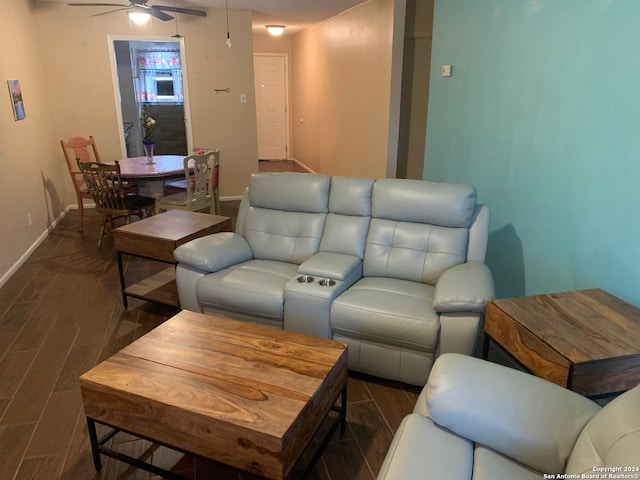 living room featuring ceiling fan and dark wood-type flooring